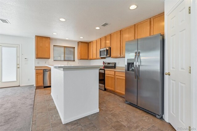 5798 Biscay St, Denver, CO 80249 - kitchen with stainless steel appliances, light countertops, recessed lighting, a kitchen island, and a sink