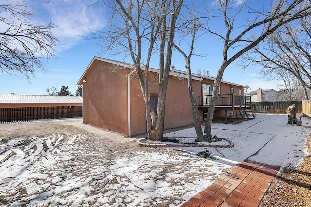 snow covered property featuring a wooden deck