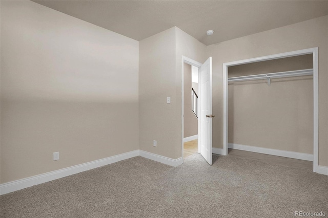 unfurnished bedroom with light carpet and a closet