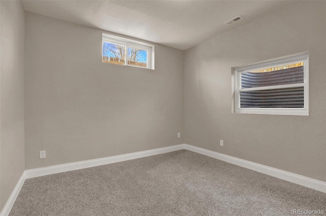 carpeted empty room with a textured ceiling