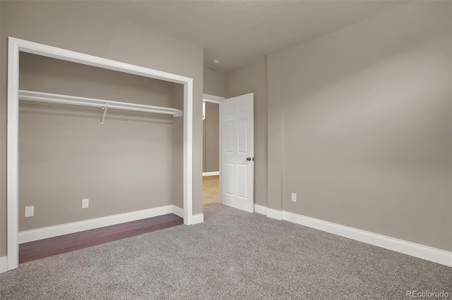 unfurnished bedroom featuring a closet and dark carpet