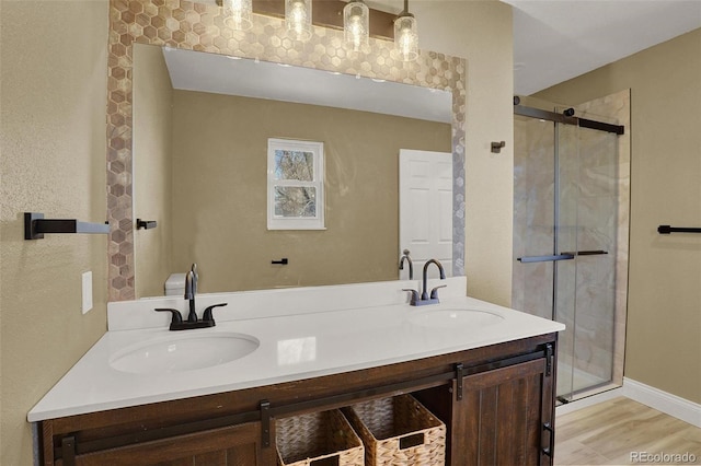 bathroom featuring vanity, wood-type flooring, and a shower with shower door