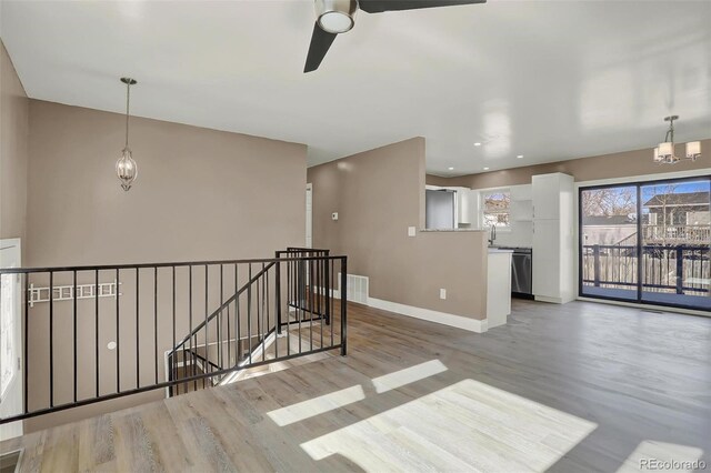 interior space with hardwood / wood-style floors, ceiling fan with notable chandelier, and sink