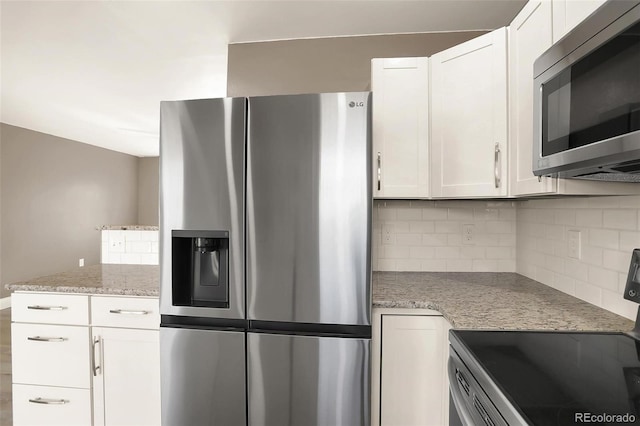 kitchen featuring decorative backsplash, appliances with stainless steel finishes, white cabinetry, and light stone counters