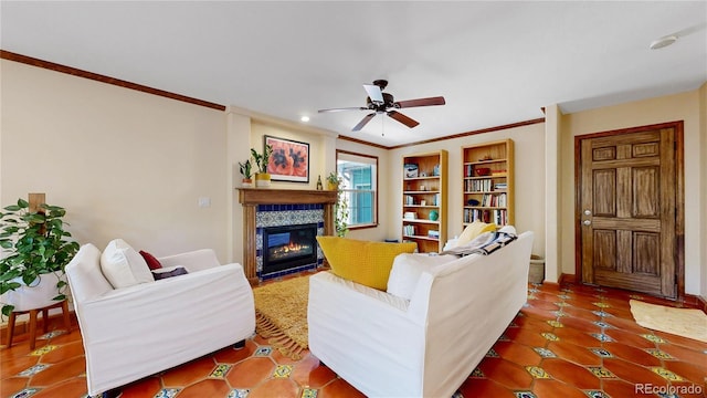tiled living room featuring crown molding, ceiling fan, a tile fireplace, recessed lighting, and baseboards