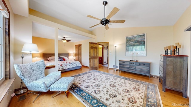 bedroom with wood finished floors, lofted ceiling, and ceiling fan
