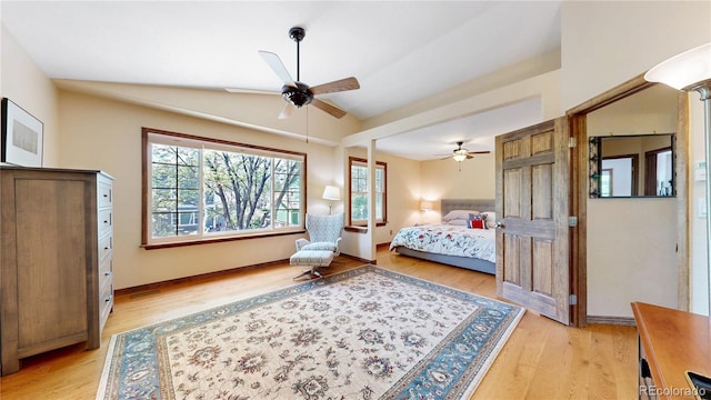 bedroom featuring multiple windows, lofted ceiling, light wood-type flooring, a ceiling fan, and baseboards