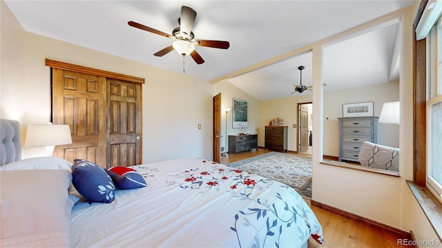 bedroom featuring wood finished floors, baseboards, ceiling fan, and lofted ceiling