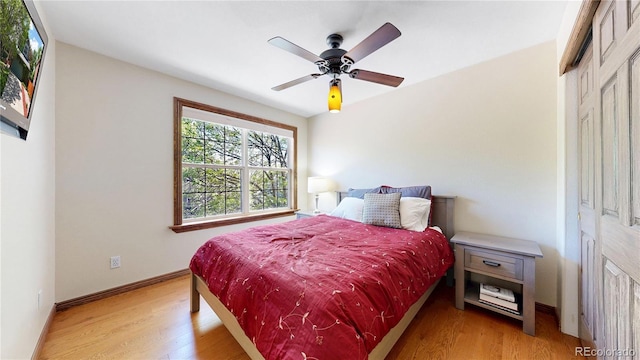 bedroom featuring light wood-type flooring, baseboards, and ceiling fan