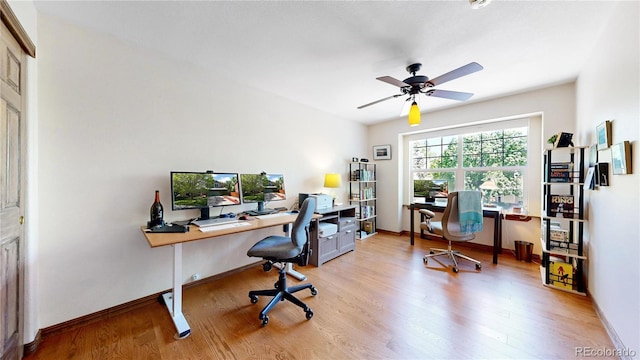 office area with ceiling fan, light wood-type flooring, and baseboards