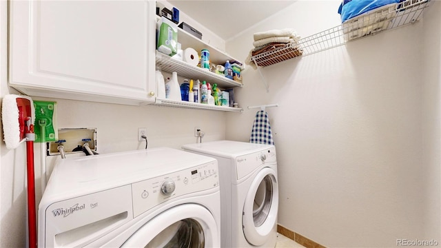 clothes washing area featuring washer and clothes dryer and cabinet space