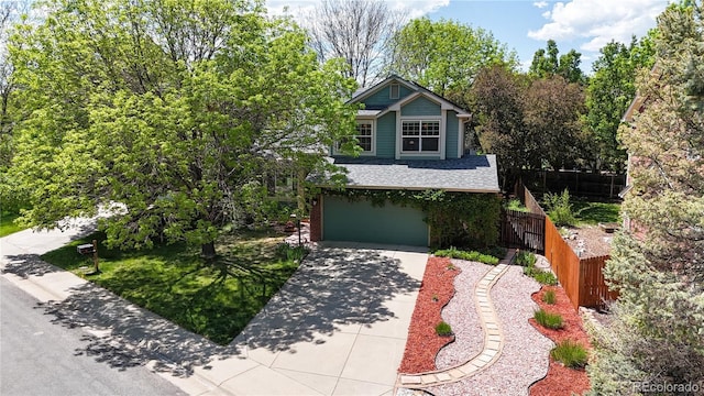 view of front of home featuring concrete driveway, fence, a garage, and a shingled roof