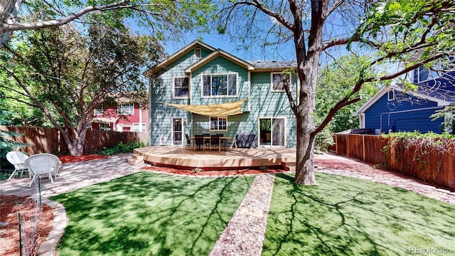 back of house featuring a wooden deck and a patio
