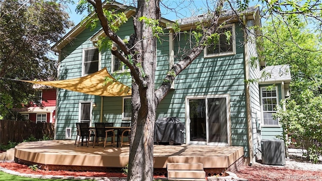 back of house with a deck and fence