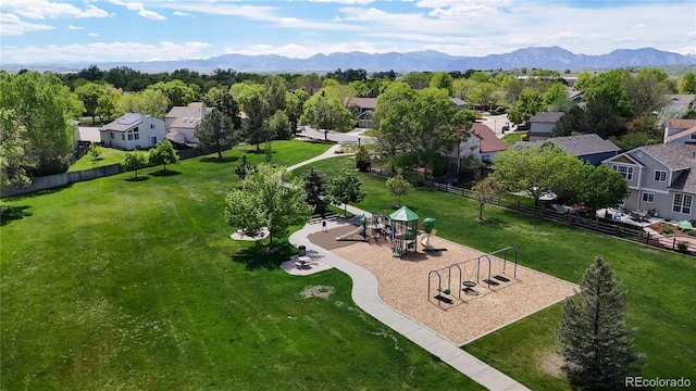 aerial view of residential area with a mountain backdrop and a community park