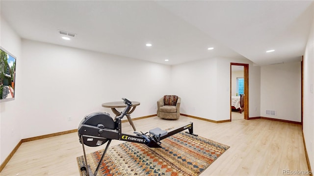 workout room featuring light wood-style flooring, baseboards, and recessed lighting