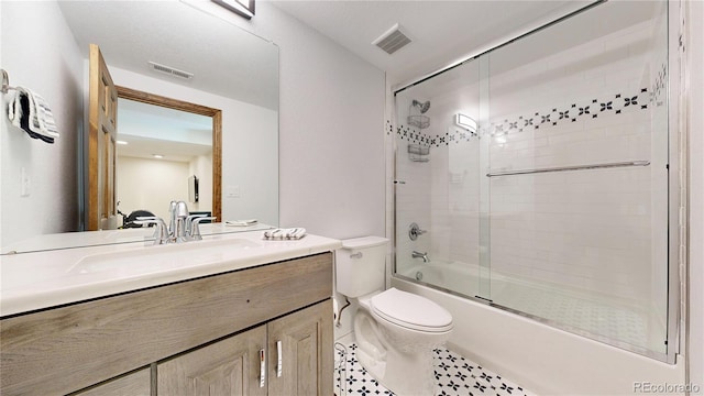 full bathroom with toilet, bath / shower combo with glass door, vanity, and tile patterned flooring