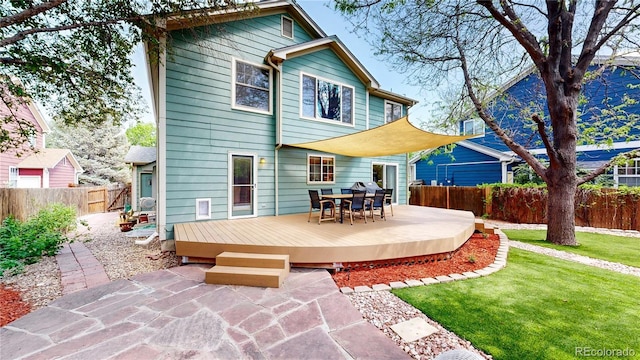 back of house featuring a deck, outdoor dining space, and a patio