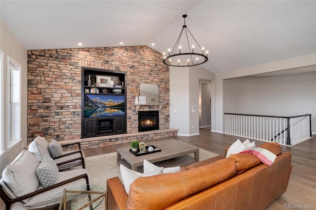 living room with lofted ceiling, a stone fireplace, wood finished floors, and baseboards