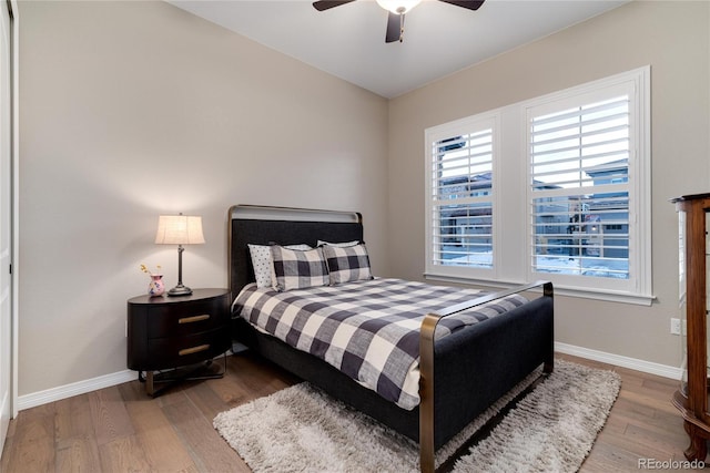 bedroom featuring a ceiling fan, baseboards, and wood finished floors