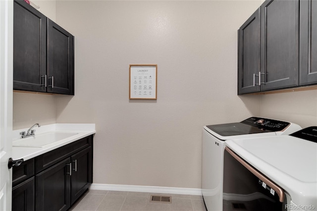 laundry area with washer and dryer, cabinet space, a sink, and visible vents