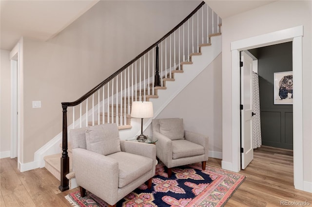 staircase featuring baseboards and wood finished floors