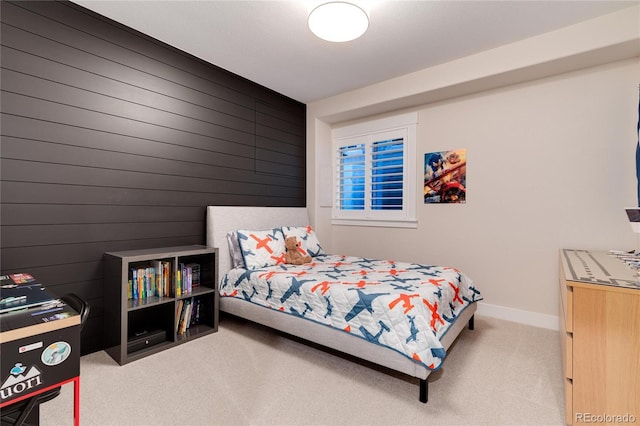 carpeted bedroom with wooden walls and baseboards