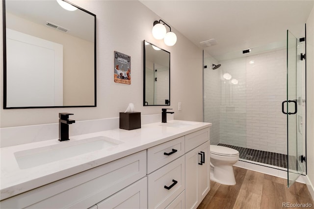 full bath with wood finished floors, a sink, visible vents, and a shower stall