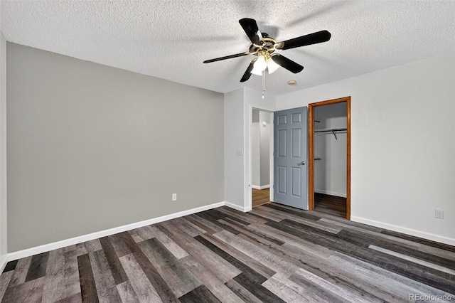 7330 Cotton Dr, Colorado Springs, CO 80923 - unfurnished bedroom with dark wood-style floors, a textured ceiling, a closet, and baseboards