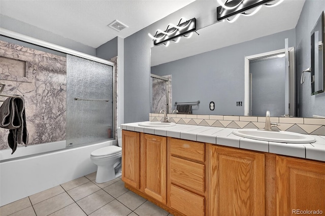 7330 Cotton Dr, Colorado Springs, CO 80923 - bathroom featuring tile patterned flooring, double vanity, toilet, and combined bath / shower with glass door