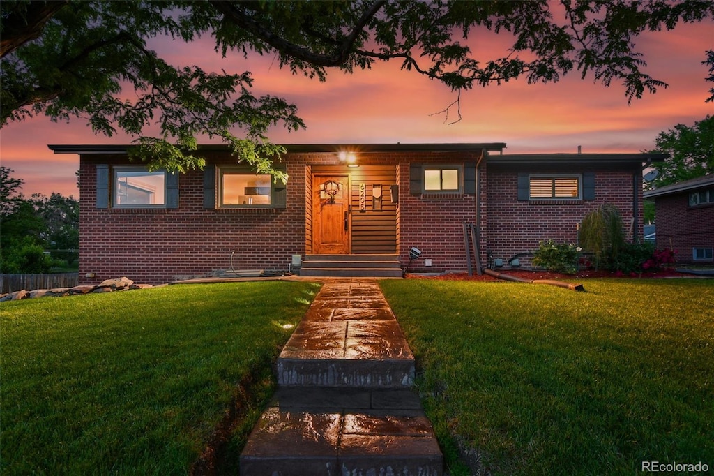 6205 Pierce St, Arvada, CO 80003 - view of front facade with brick siding, a front lawn, and crawl space
