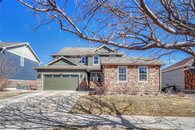 view of front facade featuring stone siding, driveway, and roof with shingles