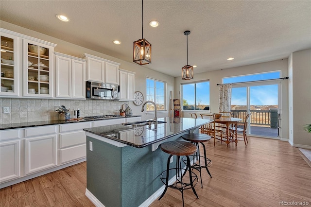 kitchen with white cabinetry, backsplash, appliances with stainless steel finishes, and a sink