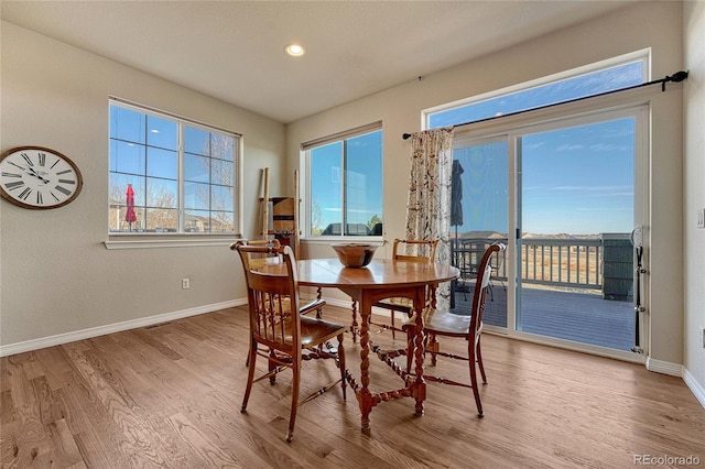 dining area with visible vents, wood finished floors, baseboards, and a wealth of natural light