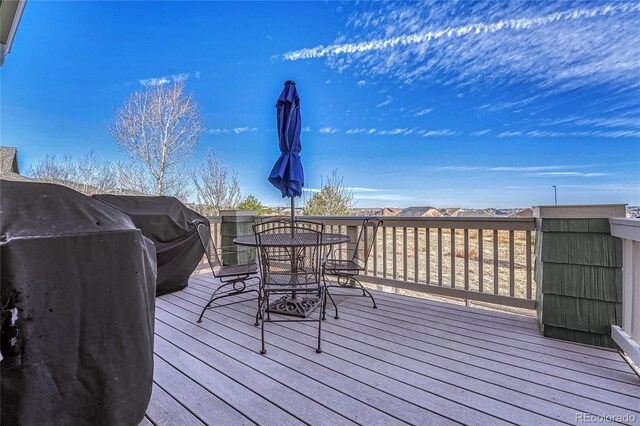 wooden terrace featuring outdoor dining space and area for grilling