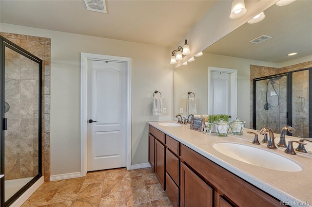 full bathroom featuring a sink, visible vents, double vanity, and a shower stall