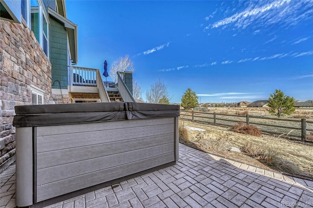 view of patio / terrace featuring fence and a hot tub