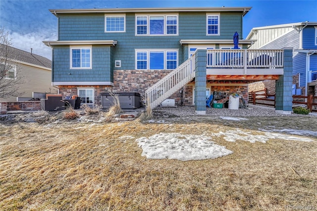 back of property with stone siding, stairway, a wooden deck, and central AC