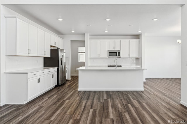 kitchen featuring a sink, appliances with stainless steel finishes, white cabinets, light countertops, and decorative backsplash