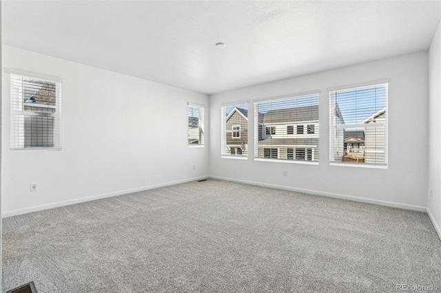 carpeted empty room with baseboards
