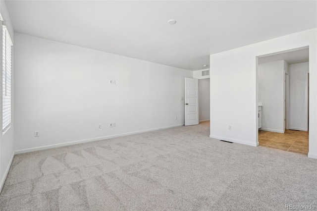 unfurnished bedroom with visible vents, baseboards, and carpet