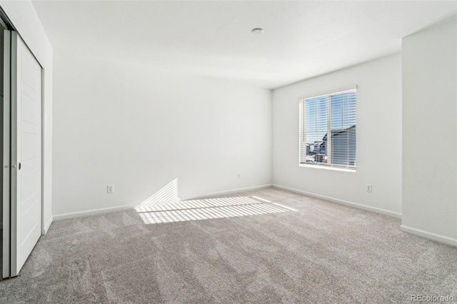 unfurnished bedroom featuring a closet, baseboards, and carpet floors