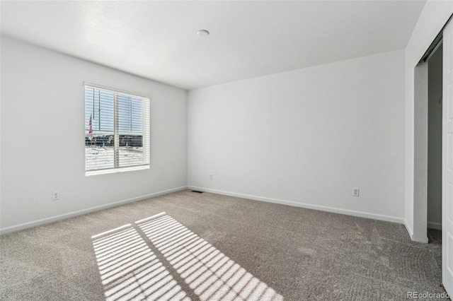 empty room with baseboards and carpet