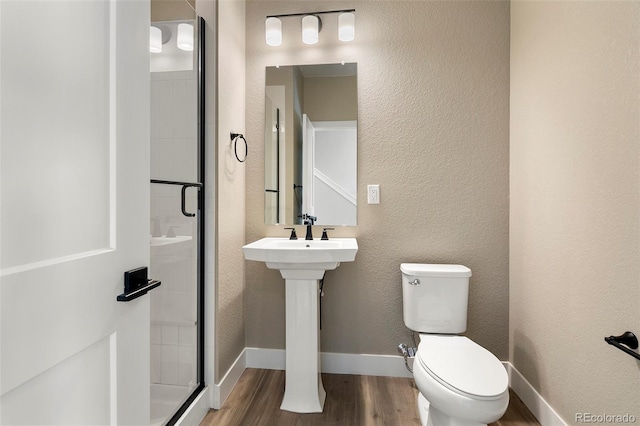 bathroom with hardwood / wood-style flooring and toilet