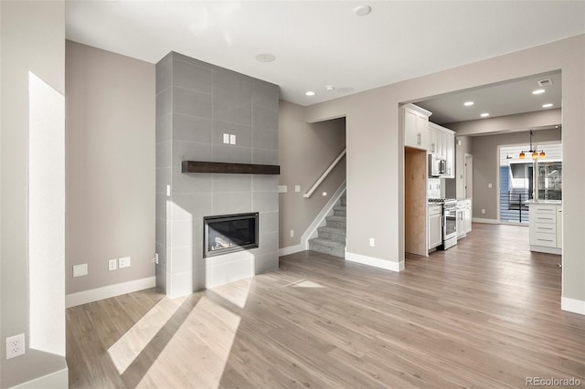 unfurnished living room featuring a fireplace and light hardwood / wood-style floors