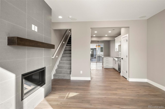 interior space featuring a tiled fireplace and light hardwood / wood-style floors