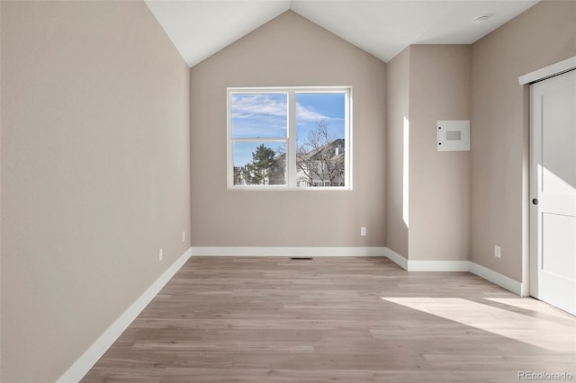 unfurnished room with lofted ceiling and light wood-type flooring