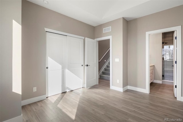 unfurnished bedroom featuring light hardwood / wood-style floors and a closet