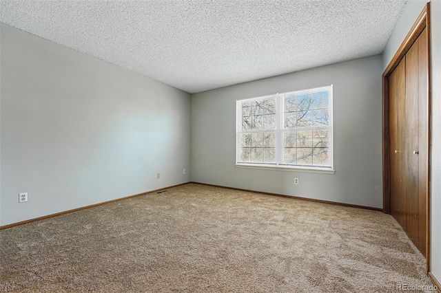 unfurnished bedroom with a closet, baseboards, and carpet floors
