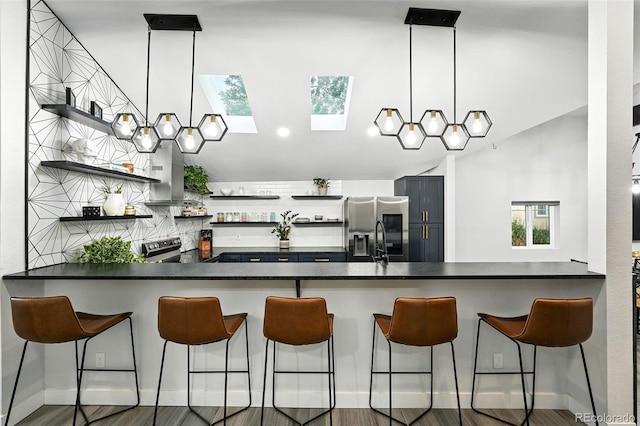 2500 Estes St, Lakewood, CO 80215 - kitchen with open shelves, stainless steel appliances, a skylight, a peninsula, and lofted ceiling